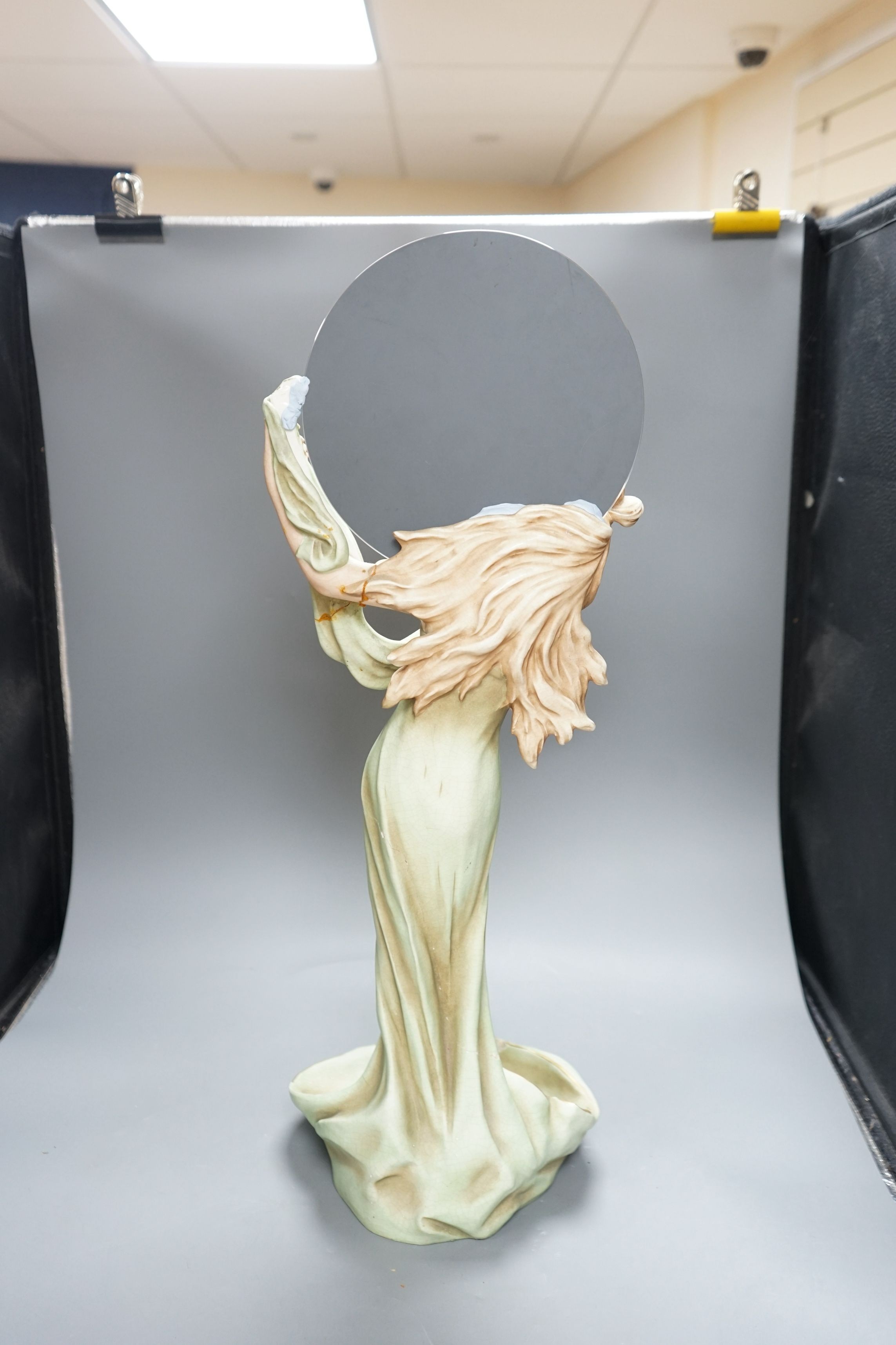 A continental Art Nouveau ceramic figure of a lady holding a mirror, 57cms high not including mirror